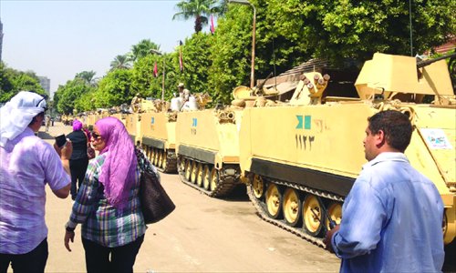 People walk past a line of tanks on September 21 in downtown Cairo. Photo: Feng Yu/GT
