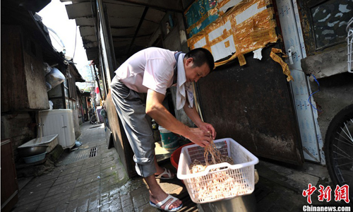 A Huashiying resident surnamed Xu prepares snacks to sell on Beijing’s streets. Xu explained he has sold food from his native Hubei Province ever since arriving in Beijing four years ago. Photo: Jin Shuo/chinanews.com 
