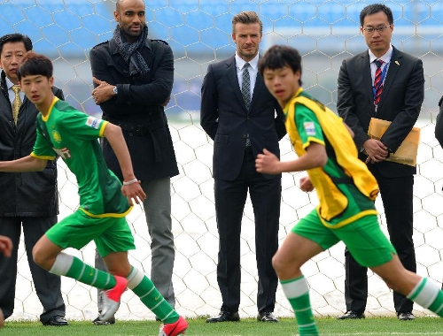 British soccer player David Beckham (2nd R Rear) watches the training of Beijing Guo'an Soccer Club's juvenile footballers in Beijing, capital of China, on March 21, 2013. Beckham visited the club as the ambassador for the youth football program in China and the Chinese Super League Thursday. (Xinhua/Gong Lei) 