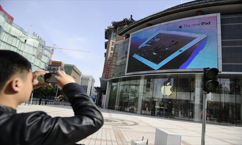 A resident snaps a  picture of the new Apple Store in Wangfujing, Dongcheng district, Thursday. The store will be the largest store of Apple Inc. in Asia, and will open on Saturday. Photo: Li Hao/GT