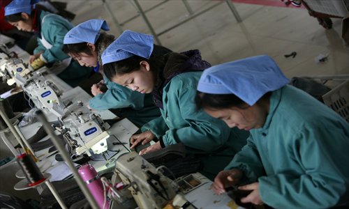 Workers sew clothes for export to the US at a garment factory in Huaibei, East China's Anhui Province Friday. The National Bureau of Statistics announced Friday that China's economy grew by 7.8 percent in 2012, the weakest since 1999. Photo: IC