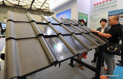 Visitors watch the photovoltaic products during the 2013 international photovoltaic exhibition in east China's Shanghai Municipality, May 14, 2013. The four-day exhibition, with the participation of more than 1,500 exhibitors, opened here Tuesday. (Xinhua/Lai Xinlin) 