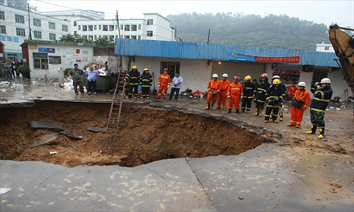 Rescuers are still searching for people buried in a hole near the gate of Huamao Industrial Park in Longgang district, Shenzhen, Guangdong Province on Tuesday, after the land collapsed to form a big hole on Monday evening. Photo: CFP
