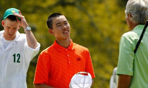 China's Guan Tianlang (C) is congratulated by Masters champion Ben Crenshaw on the 18th hole during the second round of the 2013 Masters golf tournament at the Augusta National Golf Club in Augusta, Georgia, the United States, April 12, 2013. Guan shot a three-over par 75 Friday and stood at four-over 148 after 36 holes. (Xinhua/Hunter Martin/Augusta National) 