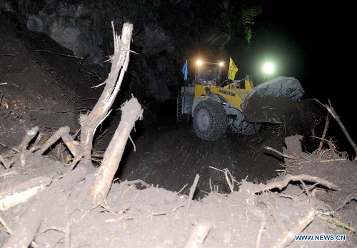   Workers of Sichuan Road and Bridge (Group) and China Railway Group rush to repair the only road heading to Lingguan Township of Baoxing County, which was badly hit by the earthquake, in Lushan County of Ya'an City, southwest China's Sichuan Province, at the midnight of April 21, 2013. A 7.0-magnitude earthquake jolted Lushan County on April 20 morning, seriously affecting the transportation from Lushan to Baoxing. (Xinhua/Luo Xiaoguang)  