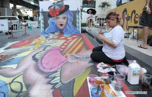 An artist draws on the ground in Bangkok, Thailand, March 2, 2013. One local artist and 19 others from over the world feast the eyes of Thai people with their 3D and 4D street paintings during the Living Arts Festival held in Bangkok.(Xinhua/Gao Jianjun) 