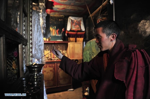 A lama prepares to chant scriptures at the Naimu Temple in Zharen Town of Anduo County, southwest China's Tibet Autonomous Region, June 26, 2013. The Naimu Temple, built in 1840, belongs to the Gelugpa sect of the Tibetan Buddhism. (Xinhua/Liu Kun)