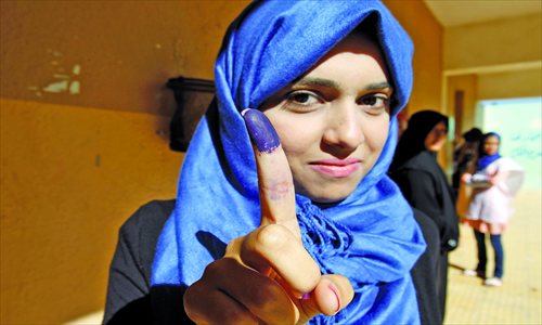 A Libyan woman shows her ink-stained finger after casting her vote to elect the General National Congress at a polling station in the eastern city of Benghazi on Saturday. Photo: AFP 