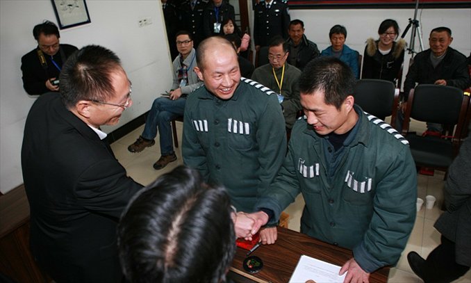An officer with Zhejiang People's High Court conveys apologies to Zhang Gaoping and his nephew after they are freed. Photo: Zhejiang People's High Court