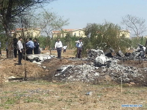 Photo taken on May 16, 2013 with a cellphone shows the site where a light plane failed to take off and crashed at Taoxian Airport in Shenyang, capital of northeast China's Liaoning Province. Three people on board were injured in the accident on Thursday. (Xinhua)
