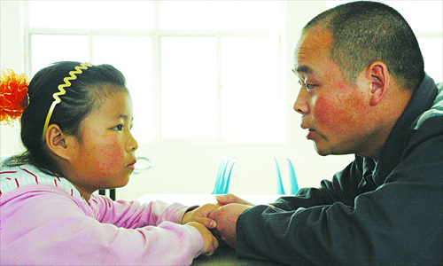 A girl visits her father He Yucheng during his jail term at a prison in Zhengzhou, Henan Province, in 2009. Photo: Courtesy of Sun Village 