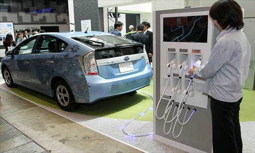 A Toyota Motor Corp’s Prius plug-in hybrid vehicle stands alongside a battery charger at the CEATEC Japan 2012 exhibition in Chiba, Japan in October 2012. Photo: CFP