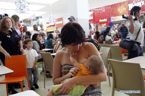 A young mother feeds her baby during a breastfeeding activity at the Plaza Lincoln shopping center in San Jose, Costa Rica, Jan. 12, 2013, to call for the rights for mothers' breastfeeding their children in public places. (Xinhua/Kent Guilbert)  