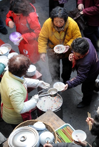 Citizens get porridge at the Xuanzang Temple in Nanjing, capital of east China's Jiangsu Province, Jan. 19, 2013, to celebrate the traditional Laba Festival. Laba literally means the eighth day of the 12th lunar month. The Laba Festival is regarded as a prelude to the Spring Festival, or Chinese Lunar New Year, the most important occasion of family reunion, which falls on Feb. 10 this year. Eating porridge is an old tradition on the Laba Festival in China. Many temples also have the tradition of offering porridge to the public to commemorate Buddha and deliver his blessings to both believers and non-believers. (Xinhua/Sun Can) 