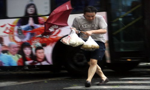 A resident walks in a rainstrom brought by Typhoon Haikui in Zhejiang province east China, August 8, 2012. Typhoon Haikui landed in Hepu Town of Xiangshan County in Zhejiang Province early Wednesday. Photo: Xinhua