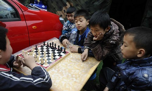 Primary school students play chess at a temporary settlement at the Hainan Middle School in Baoxing on April 24, 2013. Photo: Li Hao/GT