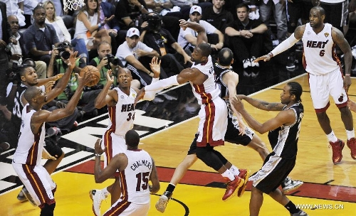 Chris Bosh (2nd L) of Miami Heat saves the ball during Game 6 of the NBA Finals against San Antonio Spurs in Miami, the United States, June 18, 2013. Miami won 103-100. (Xinhua/Wang Lei) 