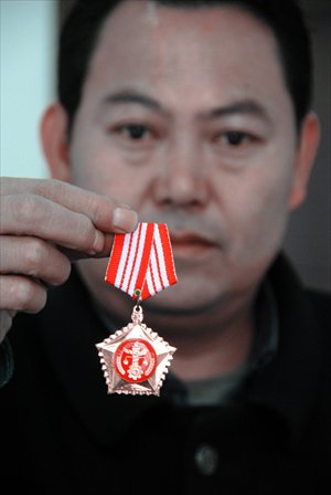 Cai Guojun, director of the court of Jinzhong township in Weining, shows his badge of office. Photo: CFP