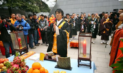 A Japanese Buddhist follower mourns the victims in front of a memorial wall on which names of the Nanjing Massacre victims are engraved, during a religious service at the Memorial Hall of the Victims in Nanjing Massacre by Japanese Invaders in Nanjing, capital of east China's Jiangsu Province, December 13, 2012, to mark the 75th anniversary of the Nanjing Massacre. Nanjing was occupied on December 13, 1937, by Japanese troops who began a six-week massacre. Records show more than 300,000 Chinese unarmed soldiers and civilians were killed. Photo: Xinhua