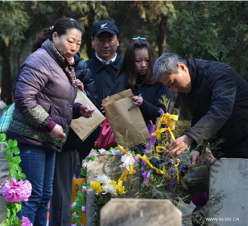 People decorate their family members' gravesite at the Babaoshan People's Cemetery in Beijing, capital of China, March 30, 2013. Citizens have begun to remember and honour their deceased family members and ancestors as the annual Qingming Festival draws near. The Qingming Festival, also known as Tomb Sweeping Day, is usually observed by the Chinese around April 5 each year. (Xinhua/Wang Quanchao) 