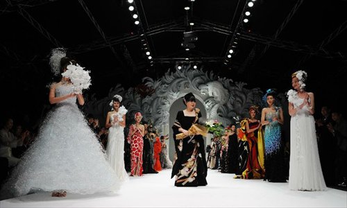 Japanese designer Yumi Katsura (C) acknowledges applause during the Japanese Couture Fashion Week at Singapore's Marina Bay Sands, on November 28, 2012. Photo: Xinhua