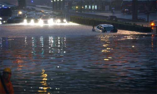 A car is submerged at Lianhua Bridge in Beijing, capital of China, July 21, 2012. A downpour hit the city on Saturday. Local meteorologic authority issued an orange alarm against heavy rains at 6:30 pm. Photo: Xinhua