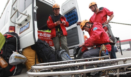 Members of the Ramunion Rescue, a rescue team from Hangzhou, capital of east China's Zhejiang Province, arrange outfit at the Xinjin Service Area on the Chengdu-Ya'an Highway after 22-hour drive in Ya'an, southwest China's Sichuan Province, April 21, 2013. Six members of the Hangzhou Outdoors Emergency Rescue Team arrived in the earthquake-hit Ya'an City after driving for consecutive 22 hours on Sunday. (Xinhua/Pei Xin)  