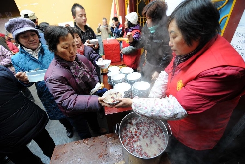  Citizens get porridge at the Xuanzang Temple in Nanjing, capital of east China's Jiangsu Province, Jan. 19, 2013, to celebrate the traditional Laba Festival. Laba literally means the eighth day of the 12th lunar month. The Laba Festival is regarded as a prelude to the Spring Festival, or Chinese Lunar New Year, the most important occasion of family reunion, which falls on Feb. 10 this year. Eating porridge is an old tradition on the Laba Festival in China. Many temples also have the tradition of offering porridge to the public to commemorate Buddha and deliver his blessings to both believers and non-believers. (Xinhua/Sun Can) 