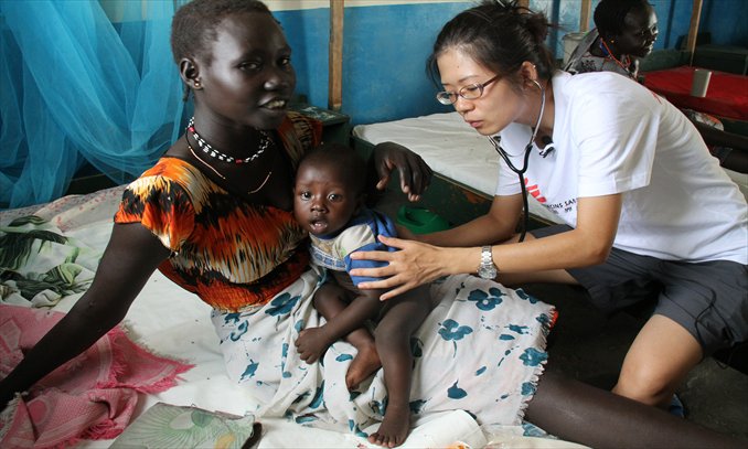 Chan Wai Chung, a doctor and a volunteer with the Médecins Sans Frontières (MSF) from Hong Kong auscultates a kid in a local clinic in Pibor, a remote town of South Sudan in 2011. Photo: Liang Zi/MSF