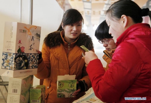 People buy tea in a Chinese new year goods market in Tengzhou, east China's Shandong Province, Jan. 30, 2013. As the spring festival drew near, people began their shopping for the celebration. (Xinhua/Song Haicun) 