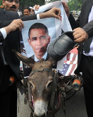 A Pakistani lawyer places a photograph of the US President Barack Obama on a donkey, against a possible US attack on Syria in response to the alleged use of chemical weapons by the Bashar al-Assad government, during a protest in Lahore on Tuesday. Photo: AFP