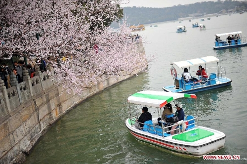 Visitors view peach flowers on boats at the Summer Palace in Beijing, capital of China, April 4, 2013. (Xinhua/Chen Yehua) 