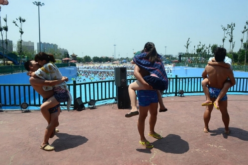 More than 20 couples participate in a romantic kissing competition held in Happy Magic Water Cube, a large-scaled water park in Beijing's Fengtai District, on July 6, 2013, the International Kissing Day. (Photo: china.org.cn / gmw.cn)