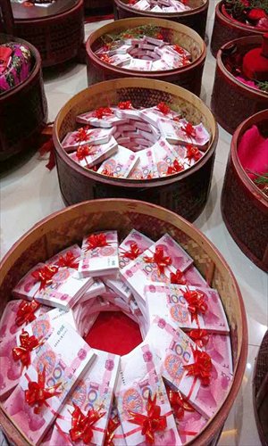 Cash totaling an auspicious 8.88 million yuan ($1.46 million) banded with red ribbons and neatly piled in bamboo baskets is delivered as a betrothal gift on Tuesday in Pujiang county, Zhejiang Province. The 100-yuan notes weighed 102 kilograms in total. Photo: IC