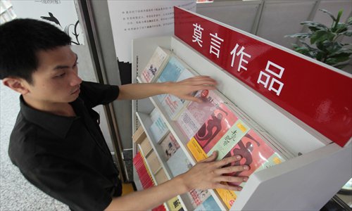 A salesman in a bookstore in Beijing arranges Mo Yan's books on a shelf. Photo: CFP