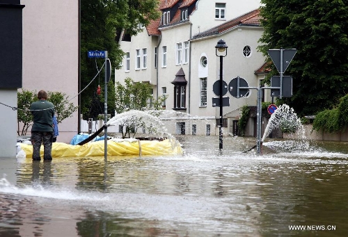 Workers drain water with pump from the evacuated residential building on the flooded street in Halle, eastern Germany, on June 4, 2013. The water level of Saale River across Halle City is expected to rise up to its historical record of 7.8 meters in 400 years, due to persistent heavy rains in south and east Germany. (Xinhua/Pan Xu)  