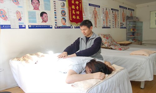 Qigong practitioner Liu Sujiang tends to a patient at his clinic in Shuangjing, Chaoyang district. Photo: Jonny Clement Brown/GT