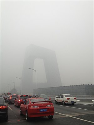 Motorists navigate a fog-shrouded road near the China Central Television Tower in Beijing's CBD. Visibility was between one and two kilometers in most parts of the city on Friday, prompting the Beijing Meteorological Bureau to issue a yellow alert for the fog. The PM2.5 reading from the Beijing Municipal Environmental Monitoring Center stood at 0.272 miligram per cubic meter Friday. Photo: CFP