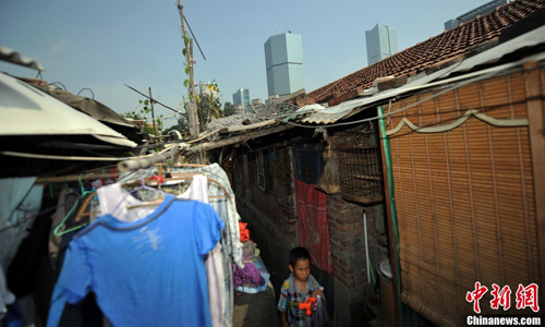 A boy plays in a narrow alley in Huashiying village. Located south of Guandongdianbei Jie in Beijing’s Chaoyang district, residents live in impoverished conditions in the shadow of the capital’s affluent business district. Photo: Jin Shuo/chinanews.com 