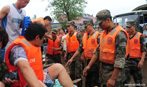 Soldiers help villagers to evacuate in Daweizi village of Xiuyan, northeast China's Liaoning Province, Aug. 5, 2012. Nearly 1.46 million people in Liaoning were affected by heavy rains and floods caused by Typhoon Damrey, authorities said Sunday. Photo: Xinhua