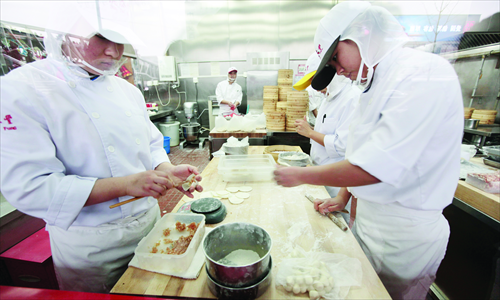 Chefs making baozi dumplings in a Ding Tai Fung restaurant's kitchen in Beijing Sunday. The Taiwanese eatery operates four outlets in Beijing and one in Tianjin, where it faces competition from venerable local rivals Qingfeng and Goubuli respectively. Photo: CFP