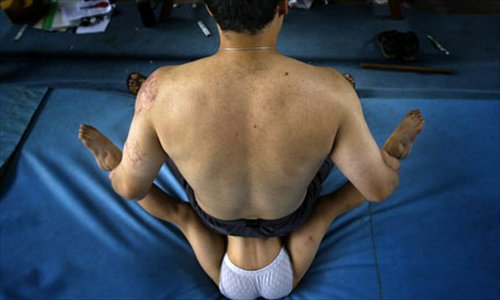 A coach helps a young student stretch at the Beijing Sports Training Center.