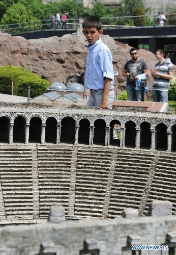A visitor looks at the miniature of Alaaddin Mosque in the Miniature park in Istanbul, Turkey, on May 11, 2013. The Miniaturk park is the first miniature park in Istanbul and has welcomed 6.5 million visitors over the past 10 years. (Xinhua/Lu Zhe) 