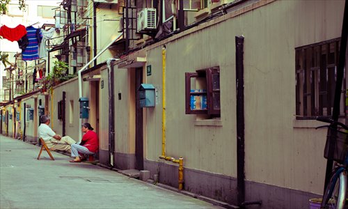 Two elderly people sit in an alley outside their home in Shanghai and chat on July 6. Photo: CFP