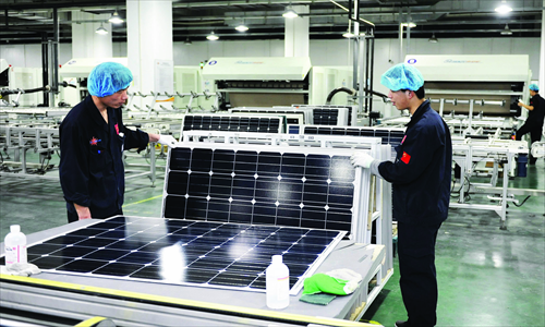 Workers examine solar panels in a factory in North China's Hebei Province. Photo: CFP