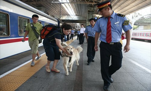 August 15, 2012, Ping and Lucky are lead by the chief conductor onto the train.Photo: Li Hao/GT