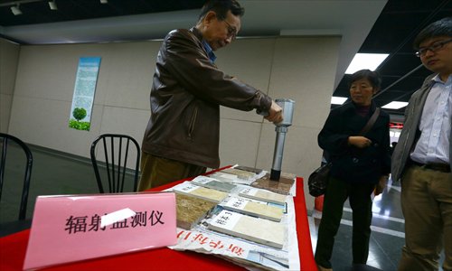 A representative of the Shanghai Environmental Protection Industry Association tests floor tiles for radiation Monday at the Shanghai Library. The association held the first of several events it sponsors each year to test home furnishings for environmental problems. The event ran from Saturday to Monday. Photo: Cai Xianmin/GT