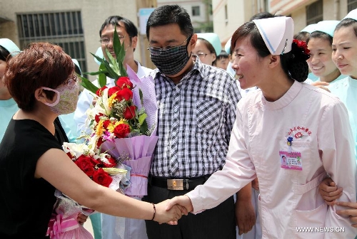 The wife (L) of the H7N9 bird flu patient surnamed Zhang (2nd R) shakes hands with a medical staff member at the Zaozhuang Municipal Hospital in Zaozhuang City, east China's Shandong Province, March 16, 2013. Zhang has recovered from the disease as the first H7N9 bird flu infection in Shandong Province. (Xinhua/Sun Zhongzhe)&nbsp; 