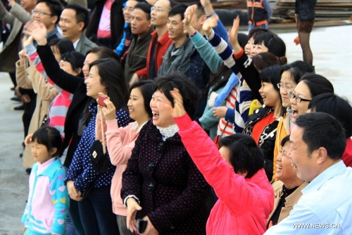 Family members of crew members on Chinese fishery patrol ship 44608 cheer for their return at Yuzheng port in Shantou, south China's Guangdong Province, March 30, 2013. The patrol ship 44608 finished its 23-day patrol cruise around Huangyan Islands on Saturday and returned to Shantou. (Xinhua/Yao Jun)  