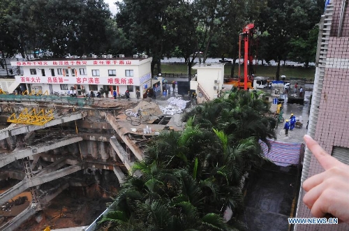 Photo taken on March 27, 2013 shows a land subsidence accident spot in a community in Futian District of Shenzhen, south China's Guangdong Province. A security guard working at the community, who happened to walk past the subsidence area, fell and died. More than 400 families in the community were cut off from water supply due to the accident. (Xinhua/Tian Jianchuan)